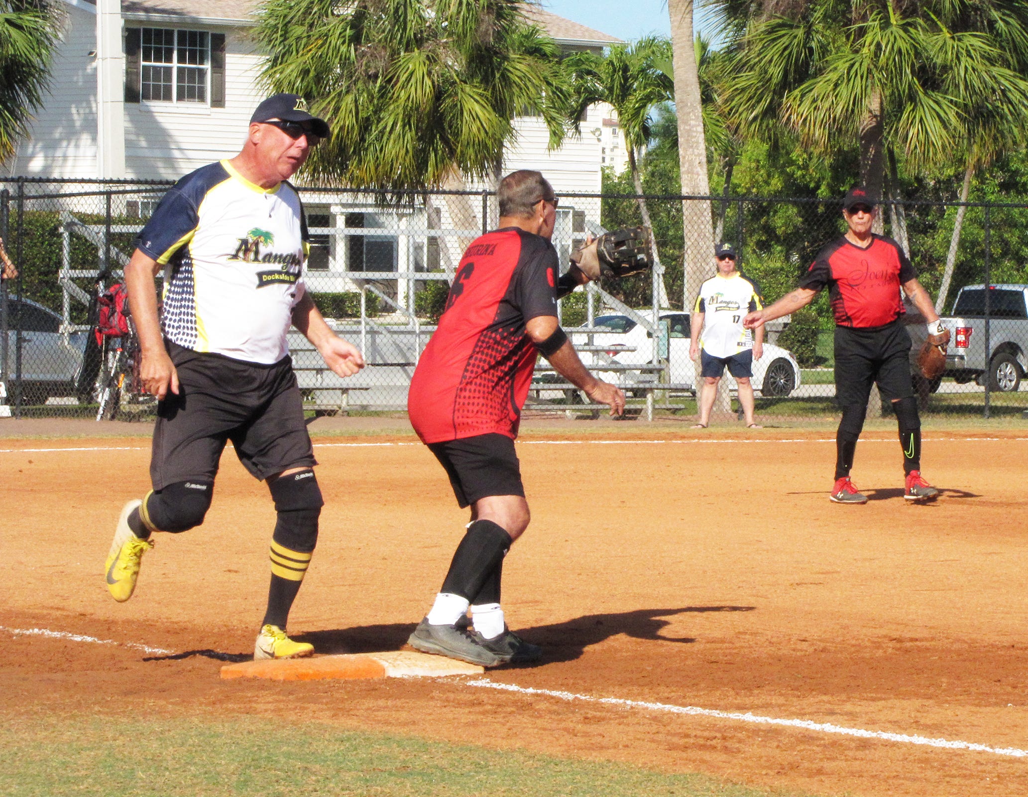 Warren Uhl of Mango’s safely crosses first base as Bill Shurina of Joey’s Pizza awaits the throw.